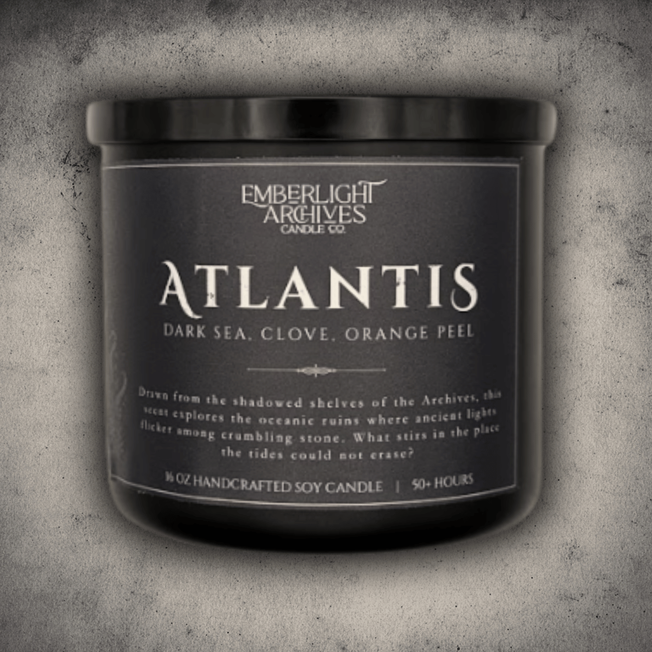 Emberlight Archives Atlantis candle in a 16oz black glass jar with dark label against a gray stone background, Dark Sea and Orange Peel scent.